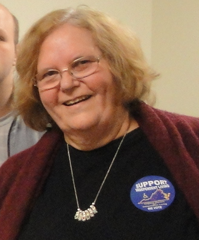 Picture of Cheryl Simpson smiling, wearing necklace and "Support IL" button.