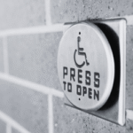 A close-up of a "Press to Open" button to activate an accessible door.