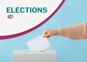 A hand drops a paper into a ballot box